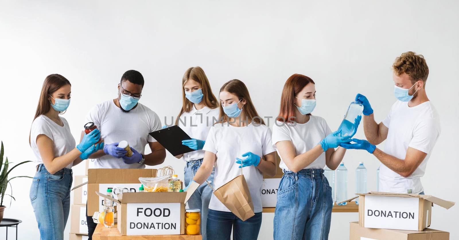volunteers with gloves medical masks preparing box donation. Beautiful photo