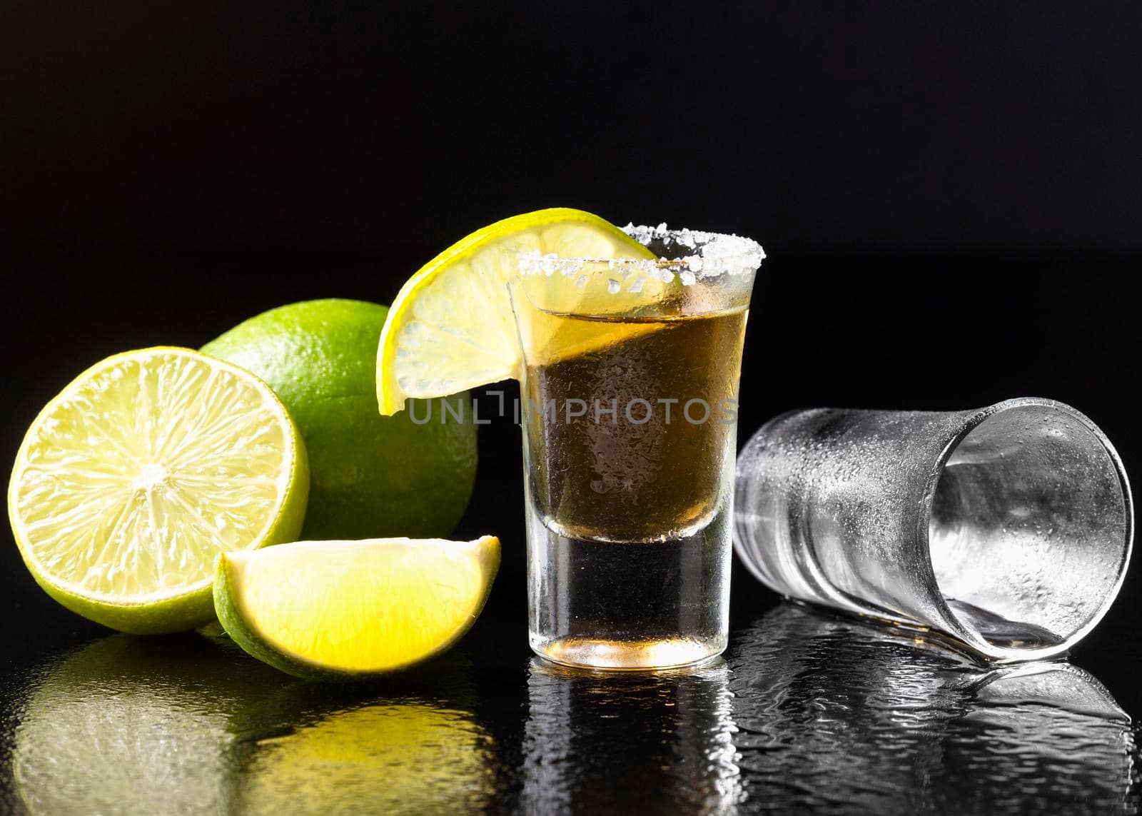 front view gold tequila shot with lime salt. High resolution photo