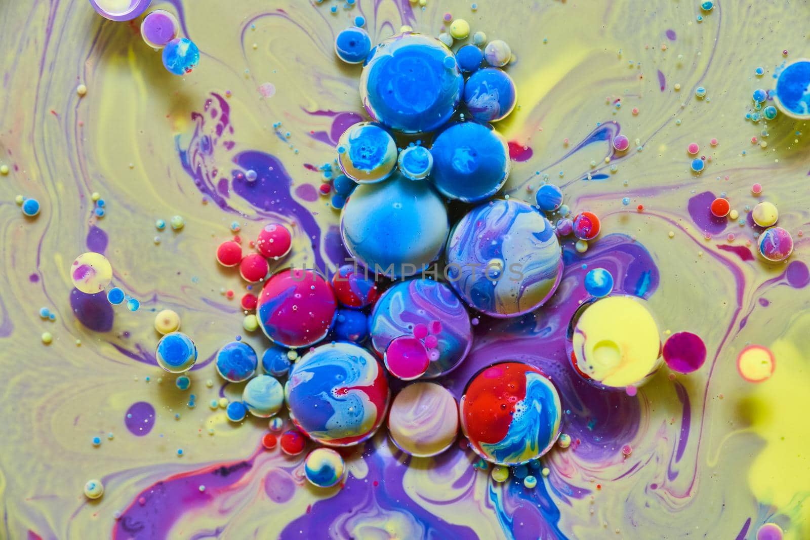 Image of Yellow and purple silky surface with colorful rainbow orbs