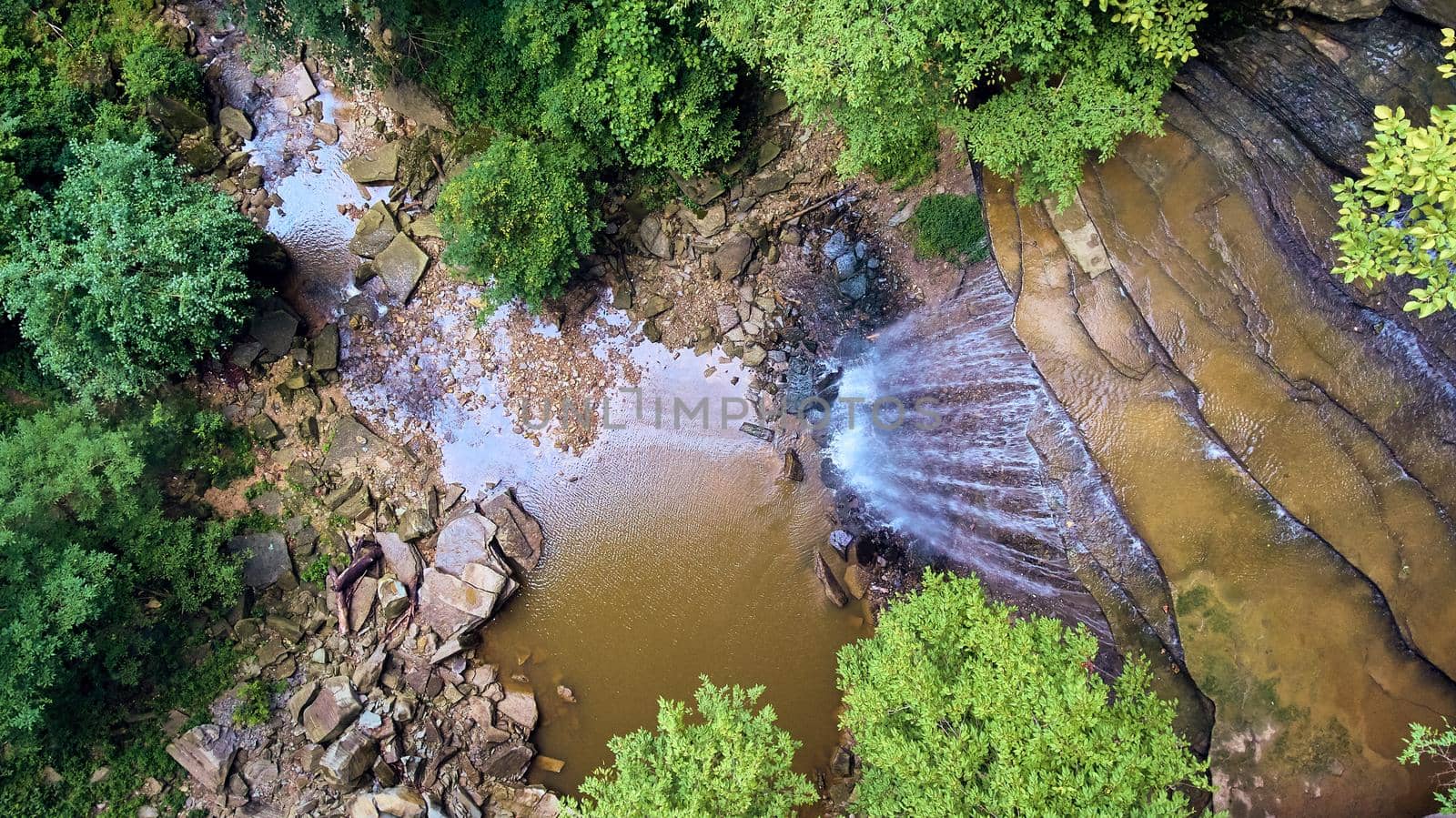 Image of Waterfalls flowing into gorge from above surrounded by woods