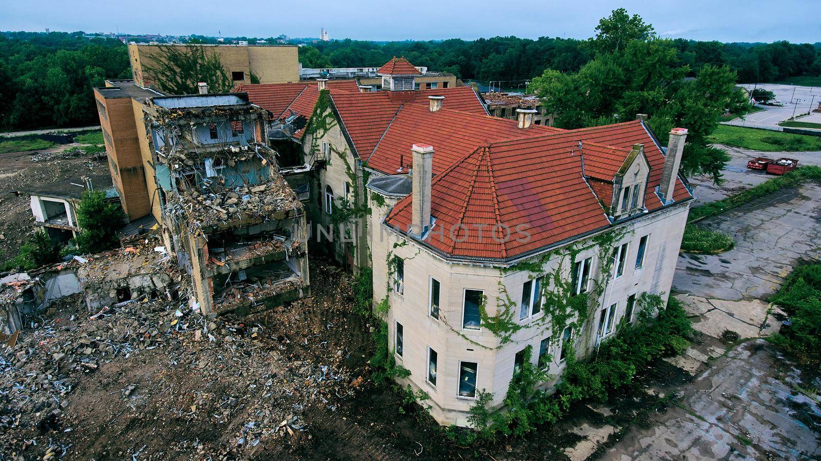 Aerial of large abandoned hospital completely falling apart by njproductions
