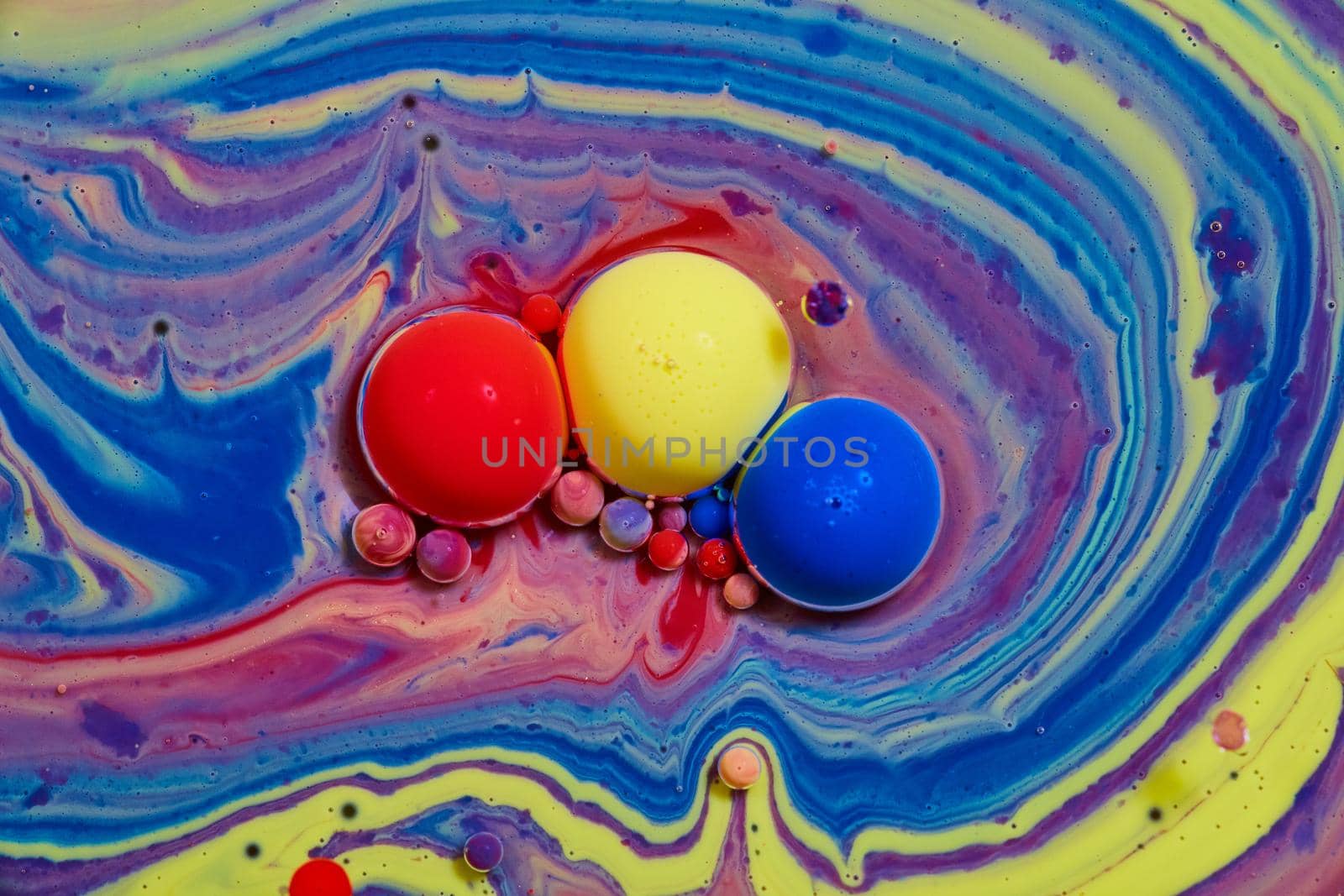 Image of Red, yellow, and blue spheres on colorful rainbow surface