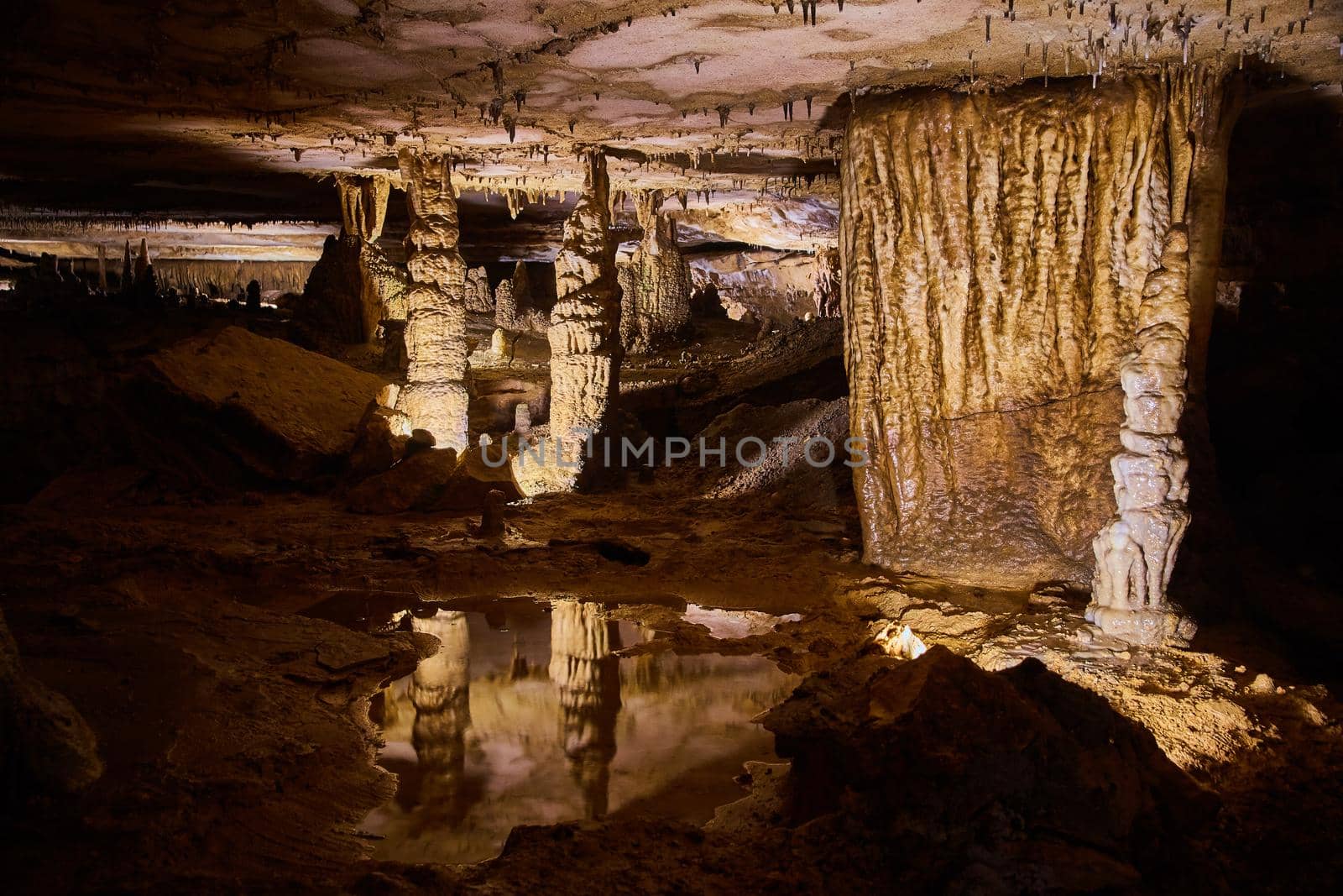 Reflecting waters of stalagmite pair in majestic cave landscape by njproductions