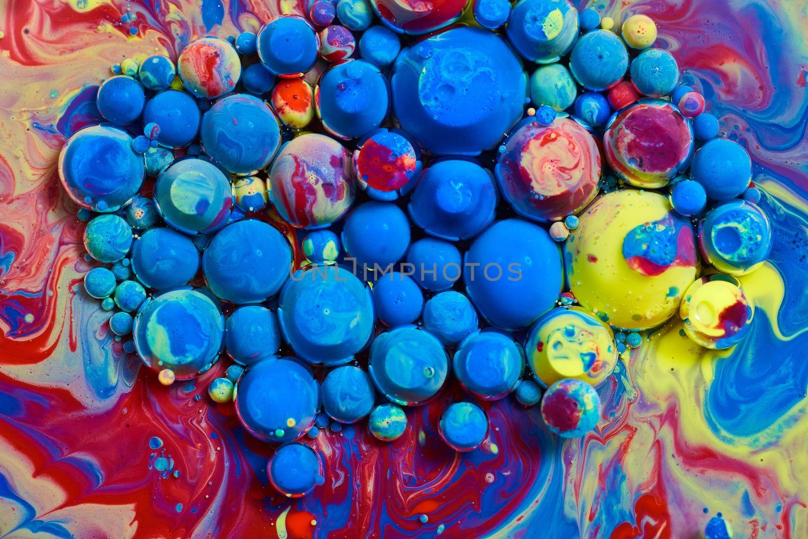 Tiny blue spheres and rainbow spheres floating on surface by njproductions