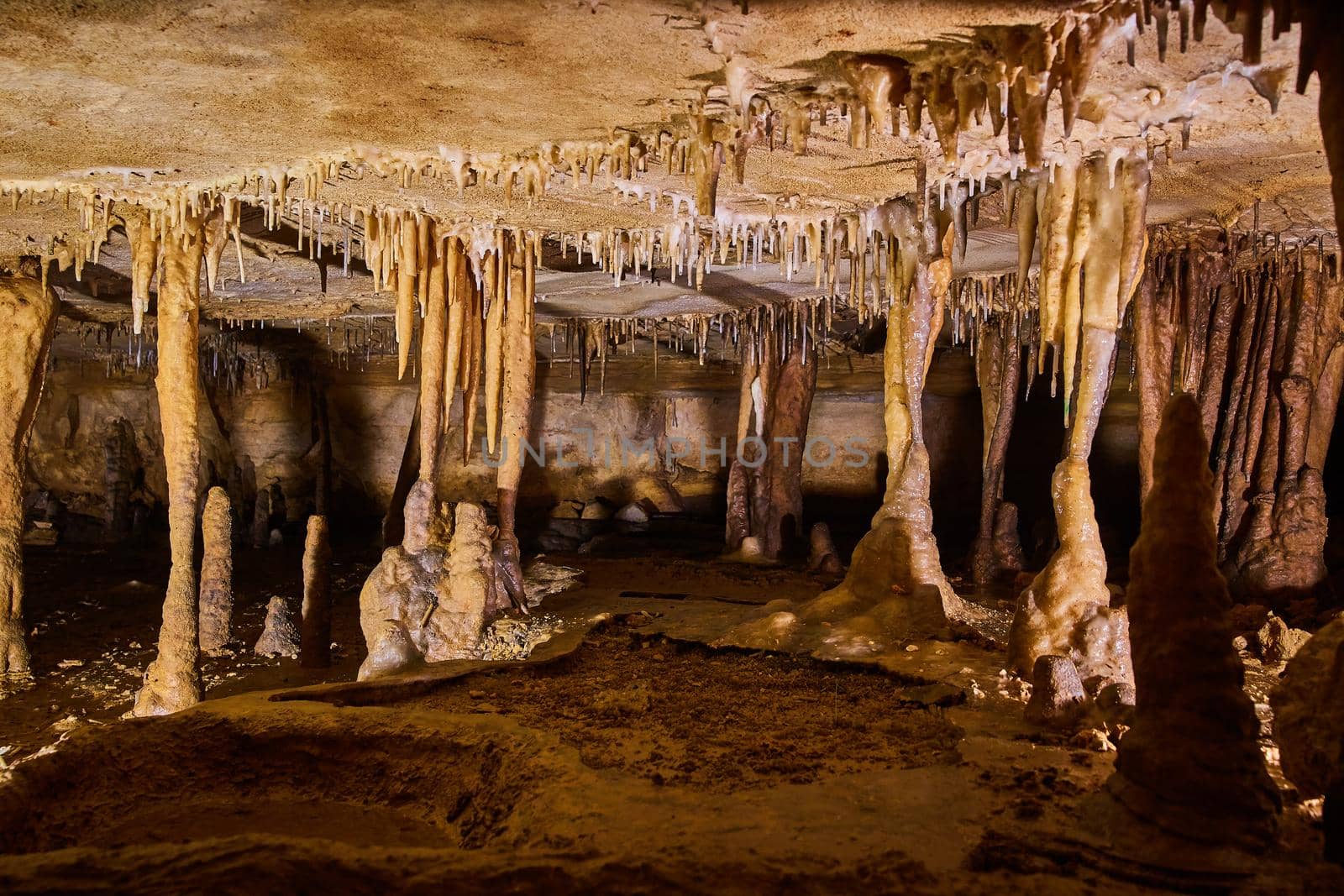 Image of Formations of stalagmites and stalactites in cave with narrow walking space