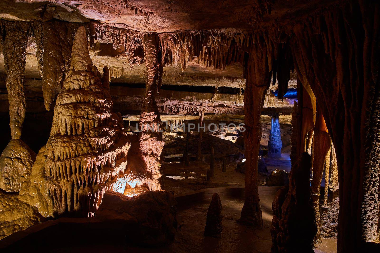 Image of Waxy stalagmites and stalactites filling large cave