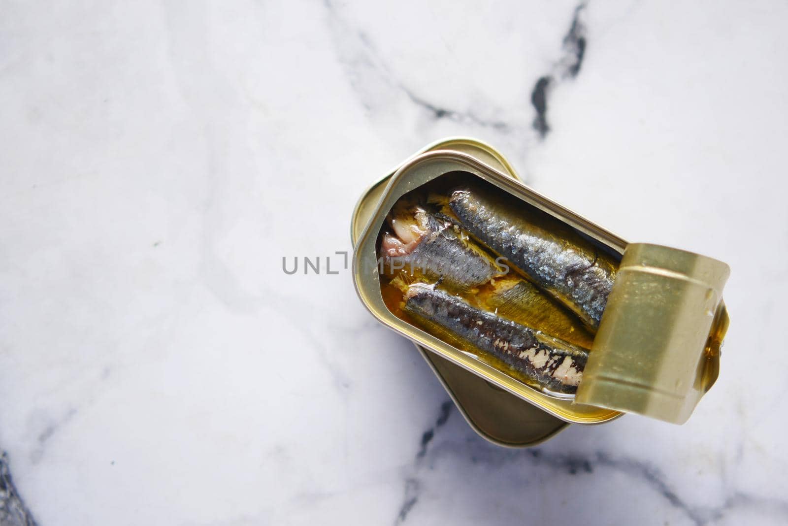 open tin of sardines on white tiles background. by towfiq007