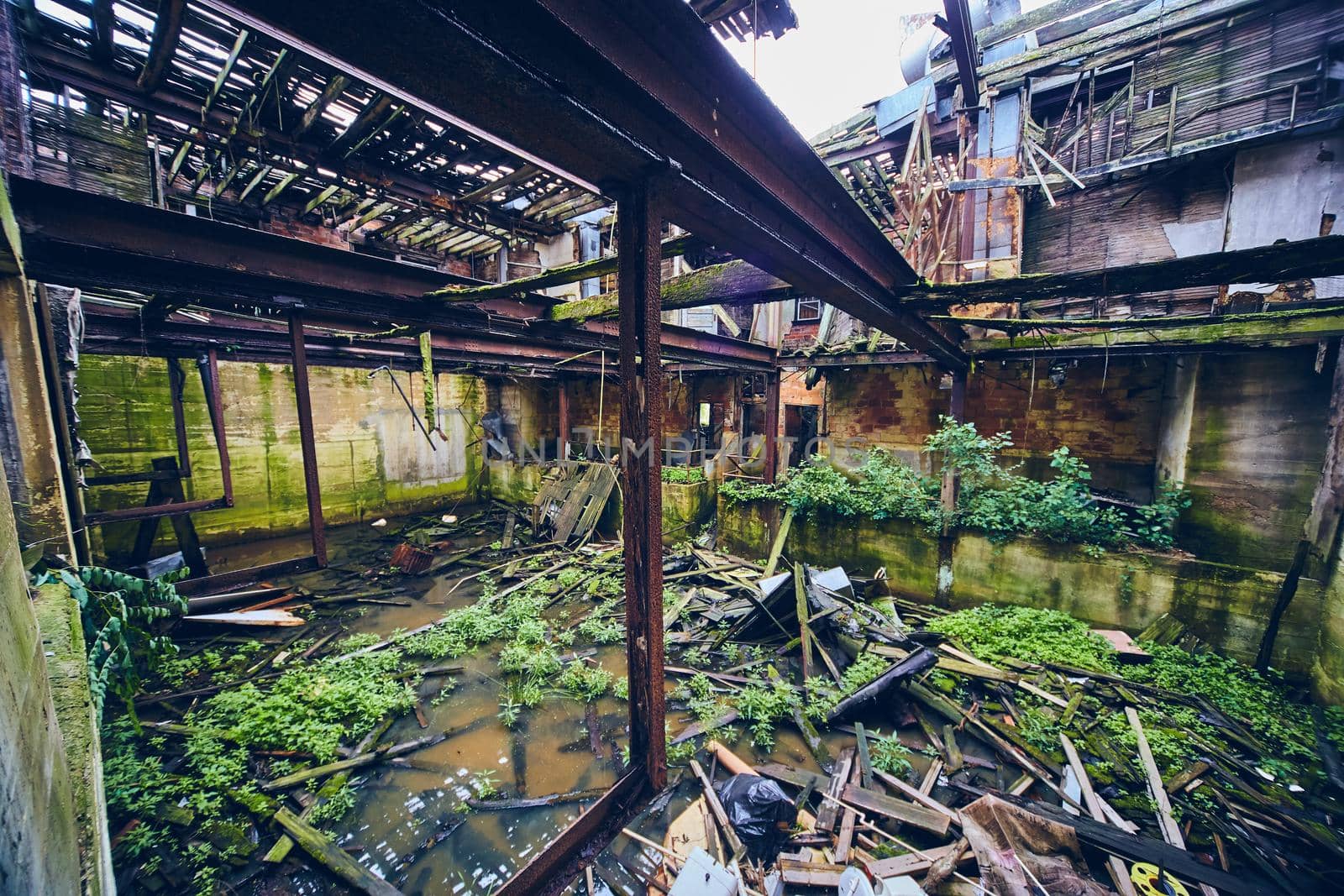 Inside large abandoned building with flooding and collapsed floors by njproductions