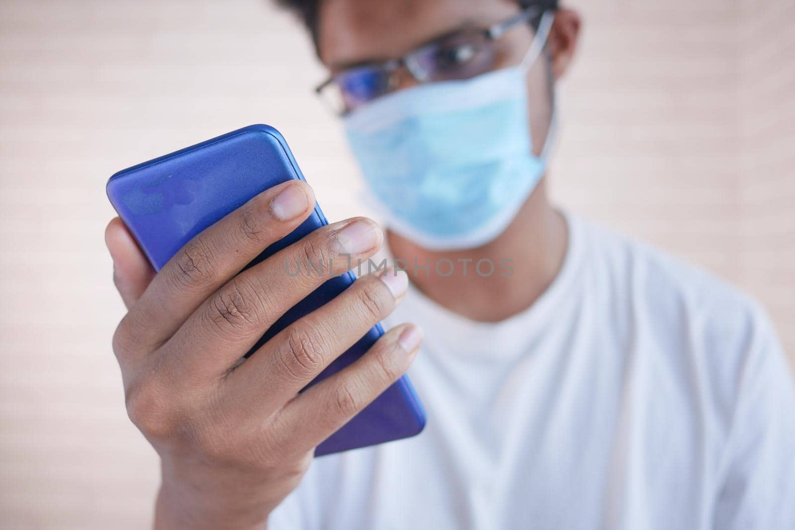 sick man in surgical face mask using smart phone, selective focus by towfiq007