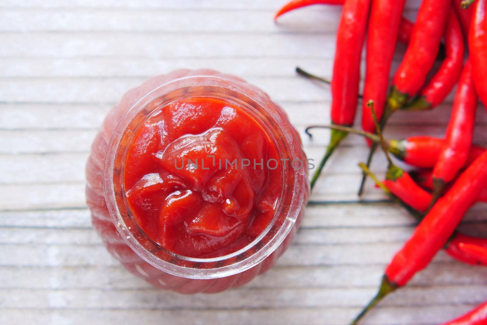 chili and tomato sauce in a small jar on table ,