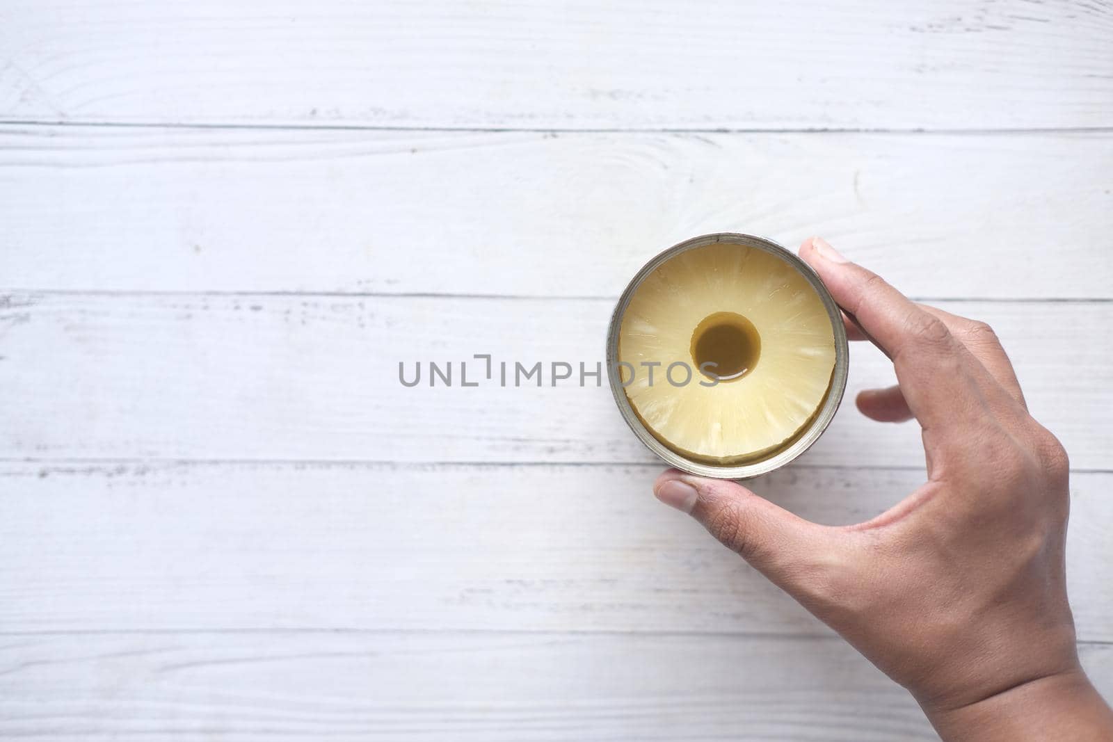 a open can of pineapple on table with copy space ,