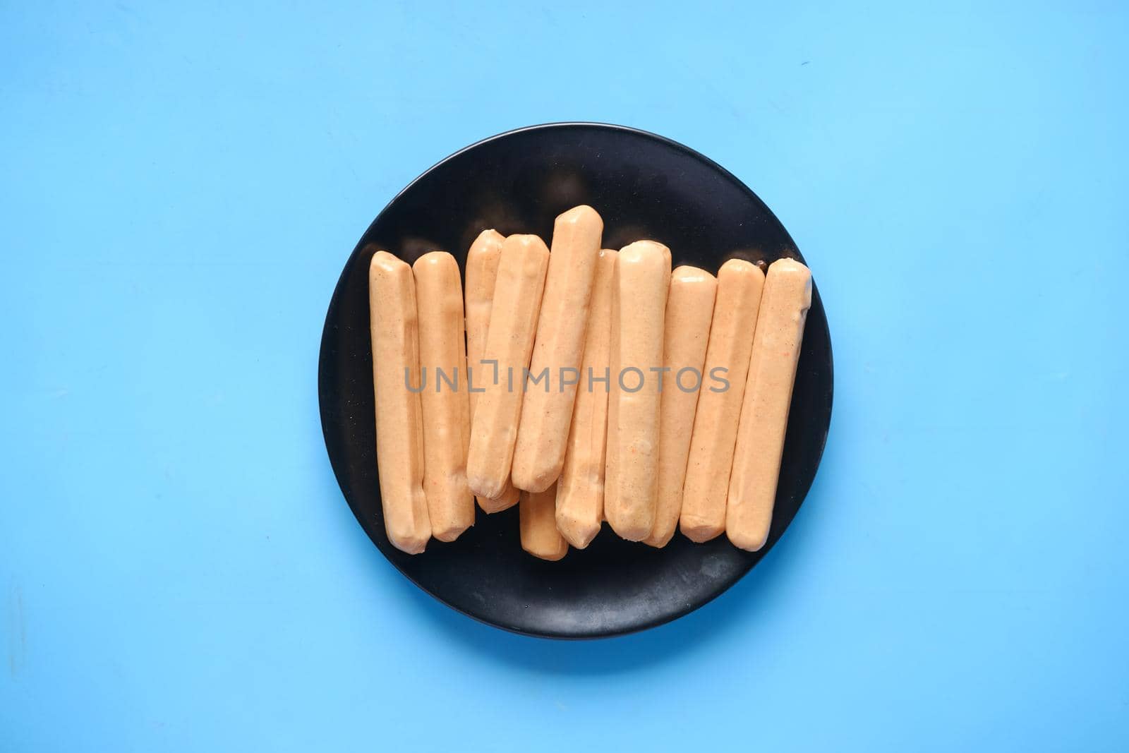 many sausages on a plate on blue background ,