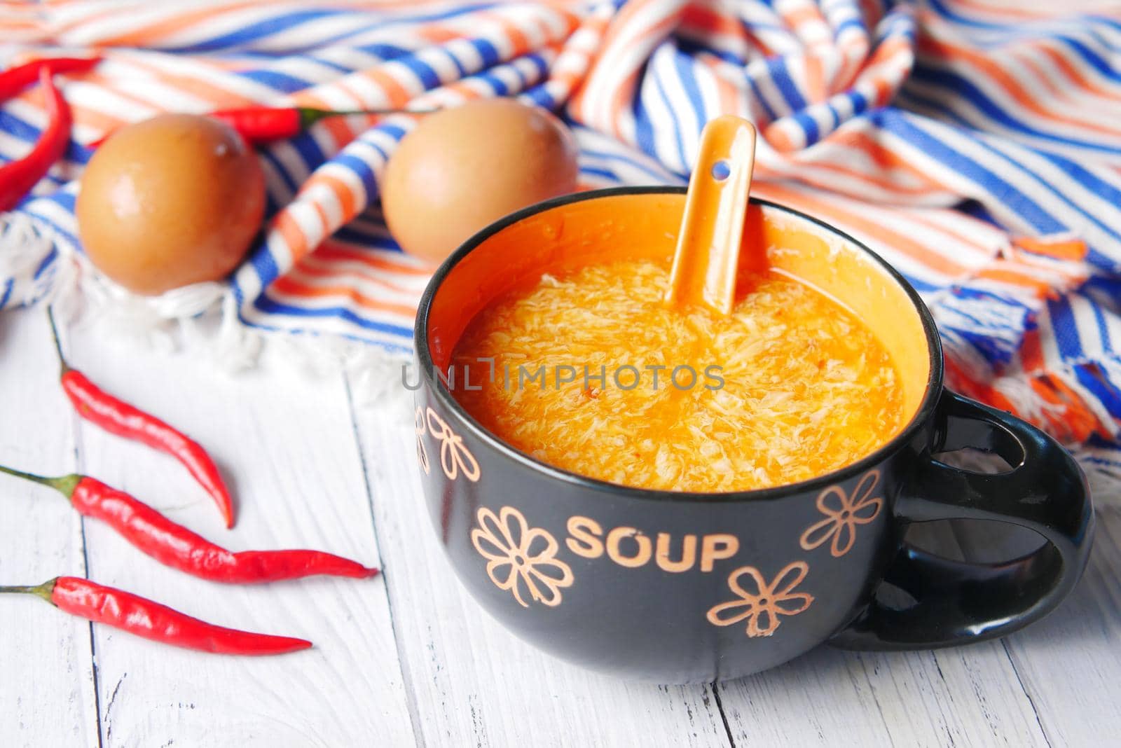 Traditional chinese egg drop soup with chili and egg on table