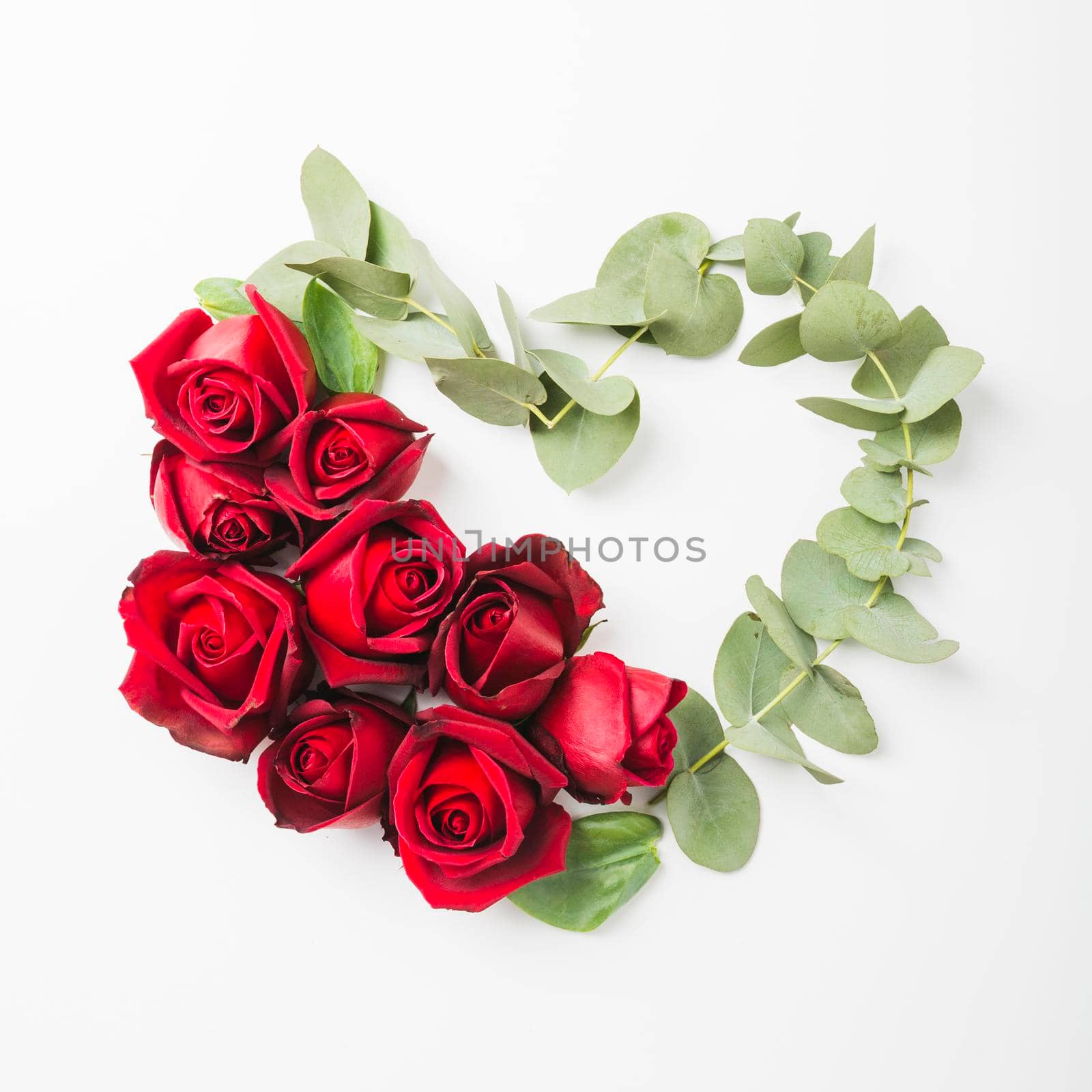 heart shape made with roses flower twig white background. High resolution photo