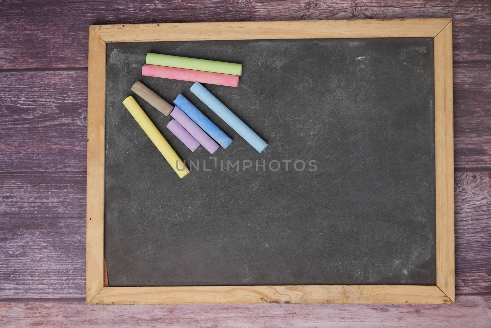 colorful chalk and chalkboard on black background .