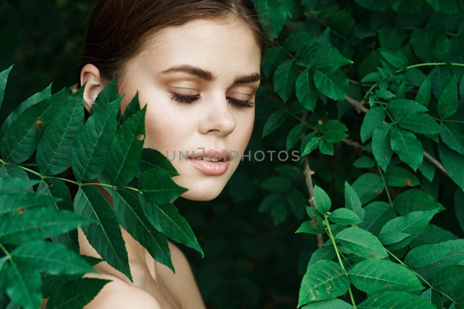 portrait of a woman Cosmetology nature green leaves glamor model. High quality photo