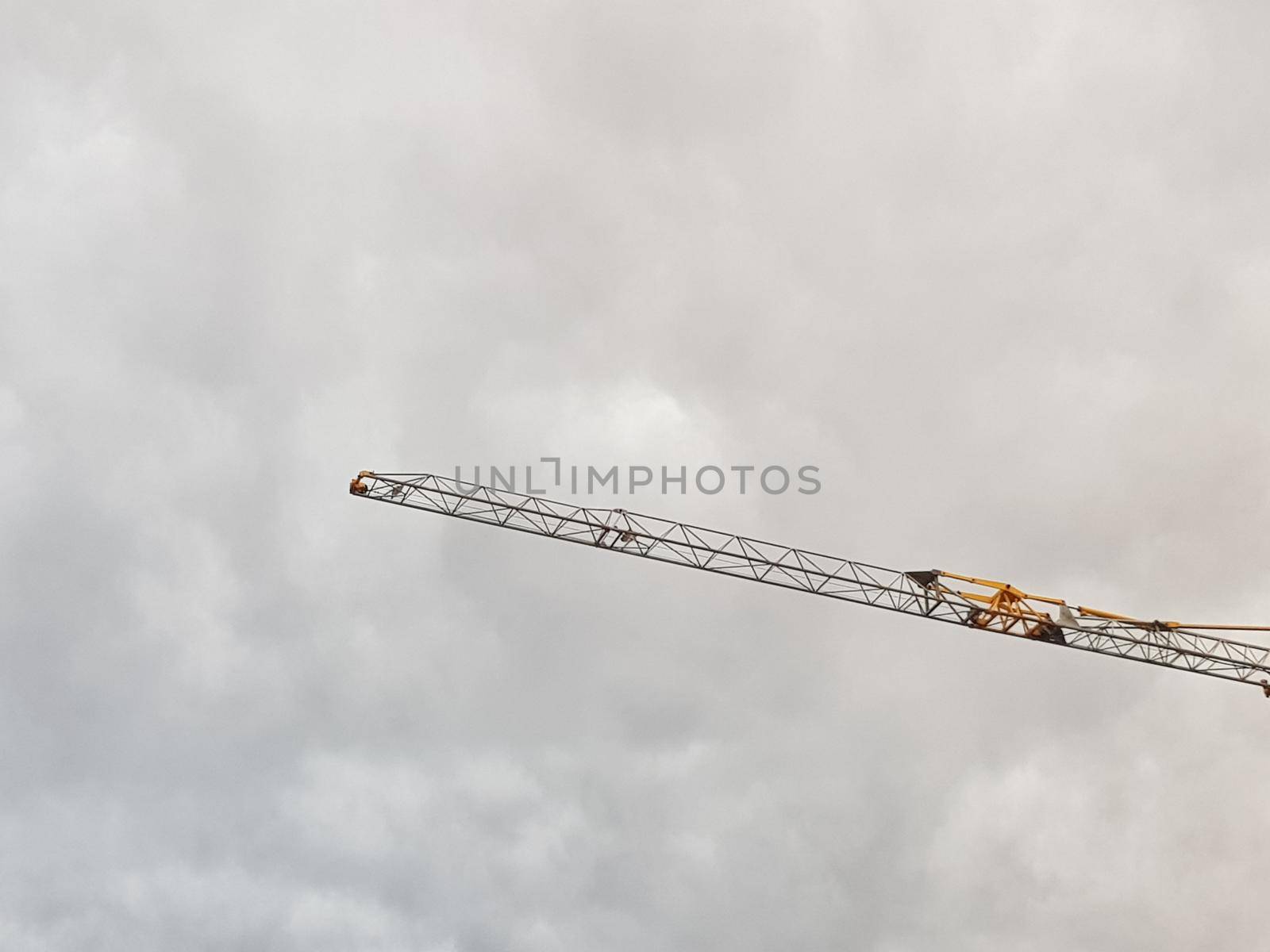 Crane hand against cloud sky. Abstract picture with negative space.