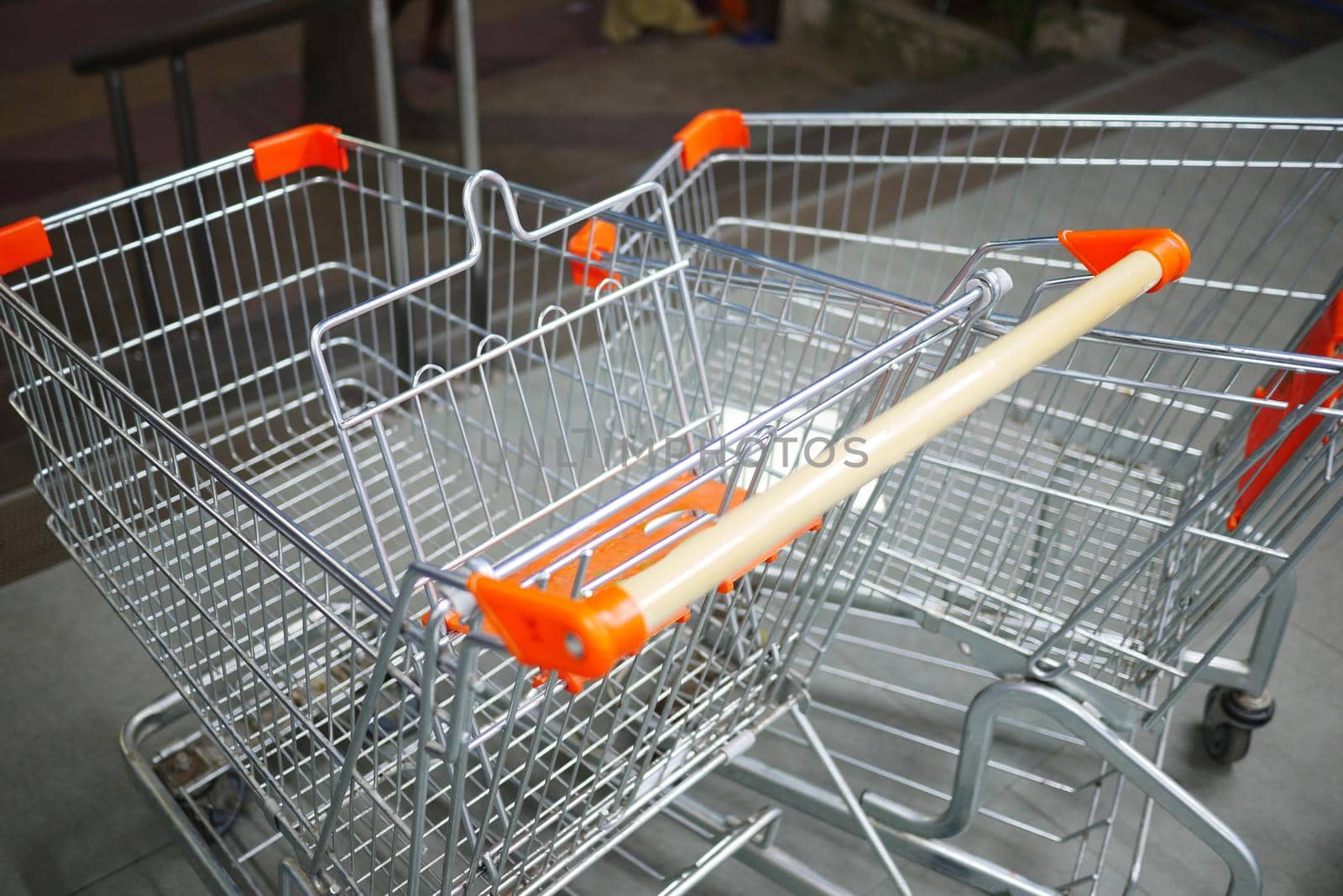 empty shopping trolley left outside of a market .