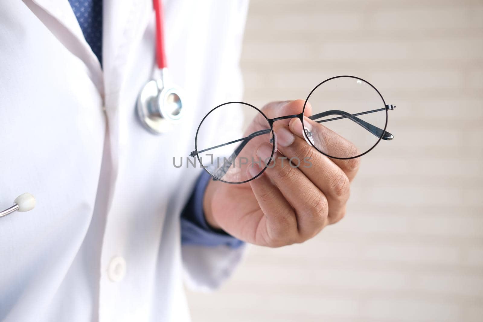 doctor hands giving pair of black glasses to patient