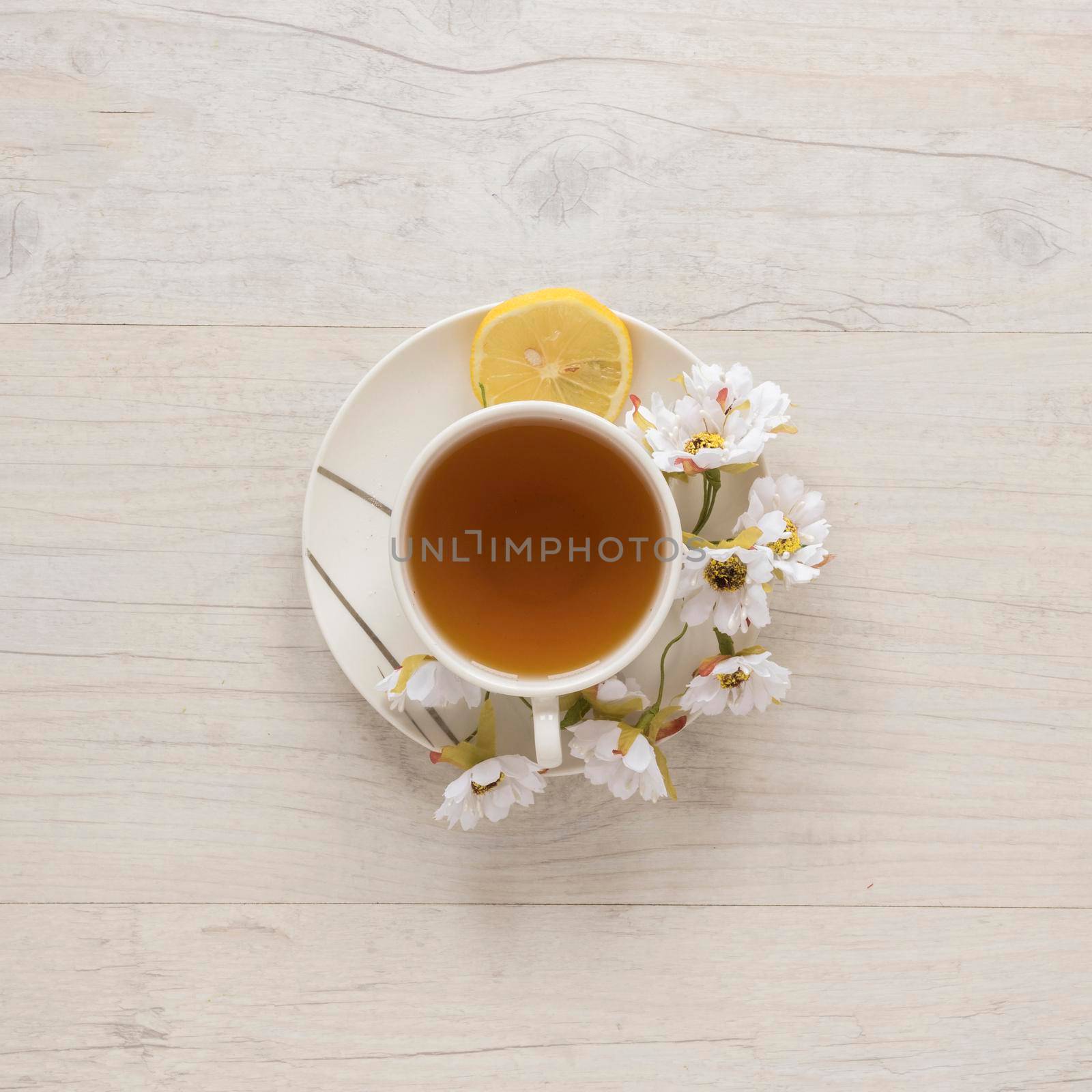 overhead view lemon tea cup with flowers lemon saucer. High resolution photo