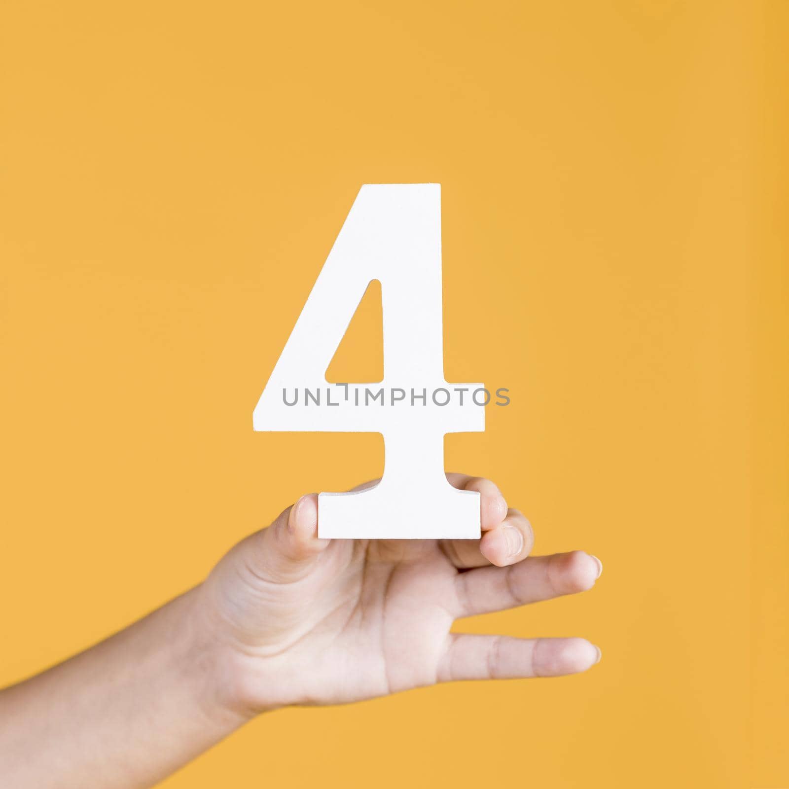 woman s hand holding up number 4 against yellow background. Resolution and high quality beautiful photo