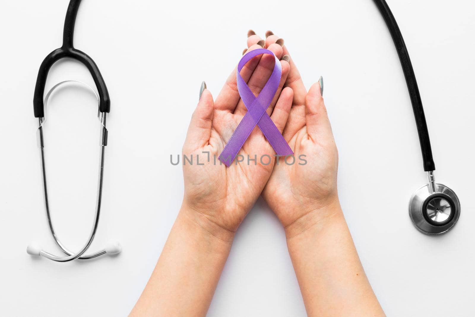 crop hands with violet ribbon near stethoscope. High resolution photo