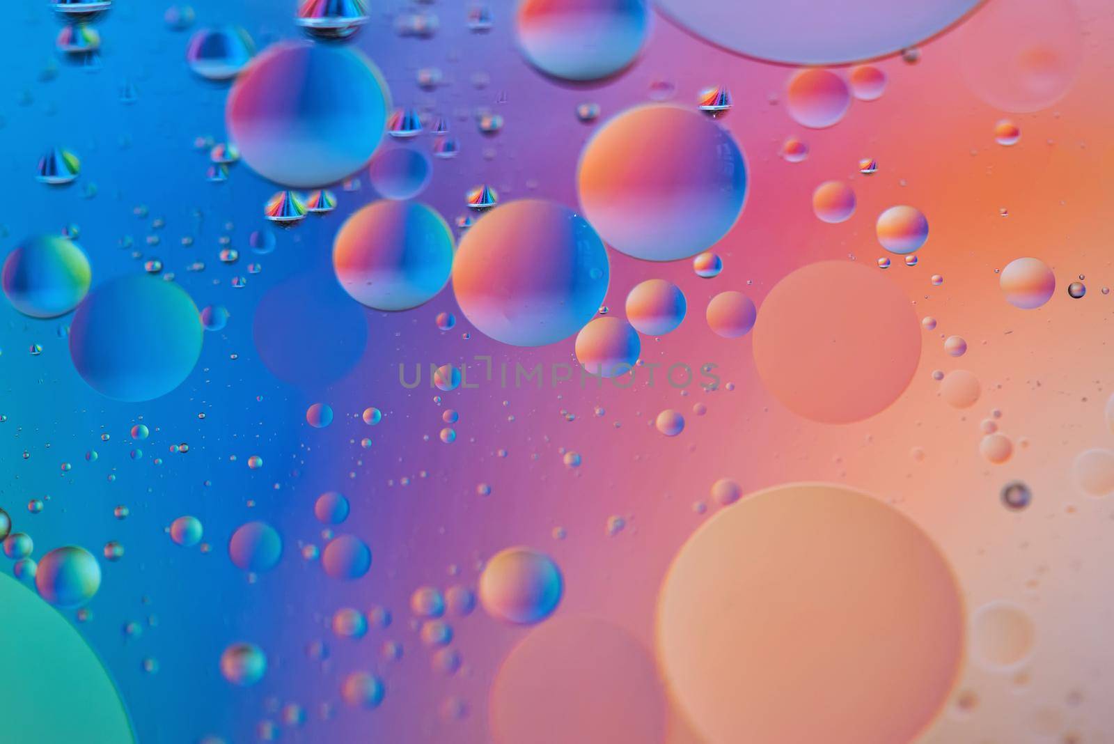 Oil drops in water. Defocused abstract psychedelic pattern image orange and blue colored. Abstract background with colorful gradient colors. DOF.