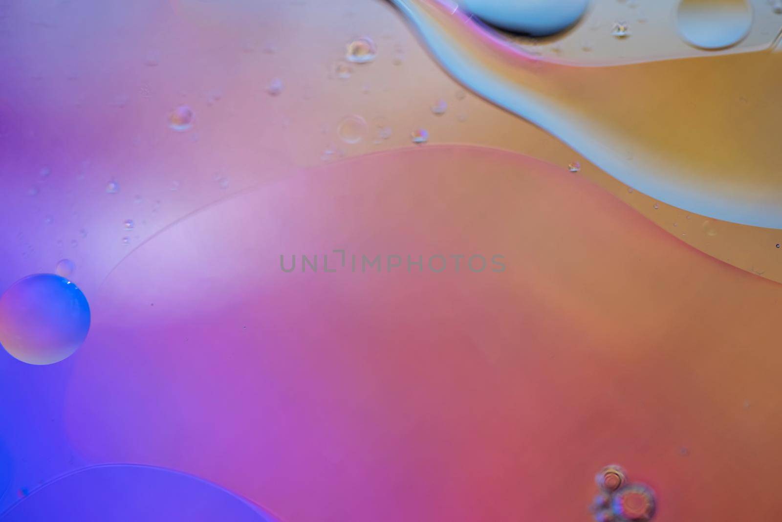 Oil drops in water. Defocused abstract psychedelic pattern image orange and purple colored. Abstract background with colorful gradient colors. DOF.