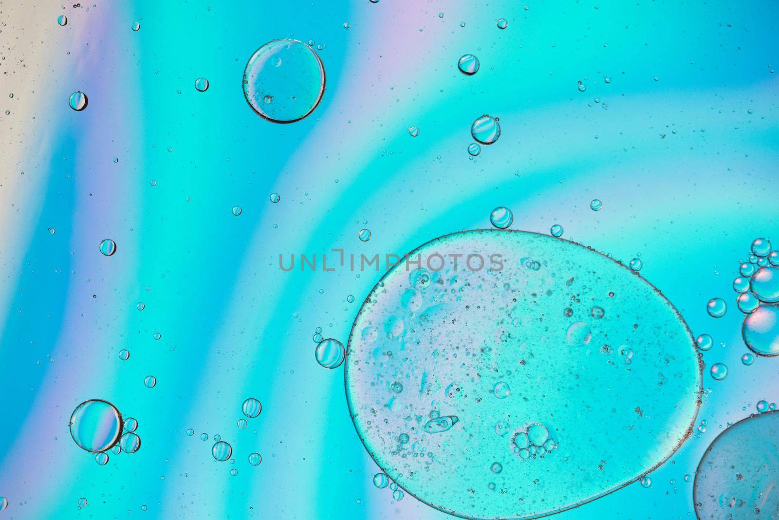 Holographic colorful abstract background with oil drops on water by anytka