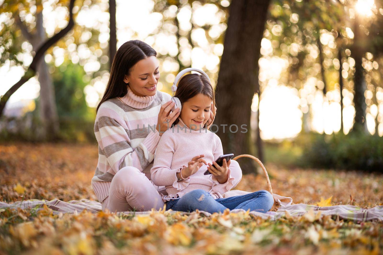 Mother and daughter enjoying autumn in park.