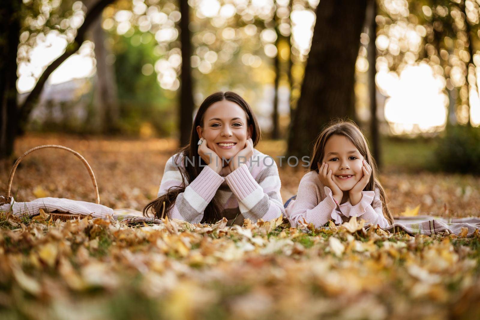 Mother and daughter enjoying autumn in park.