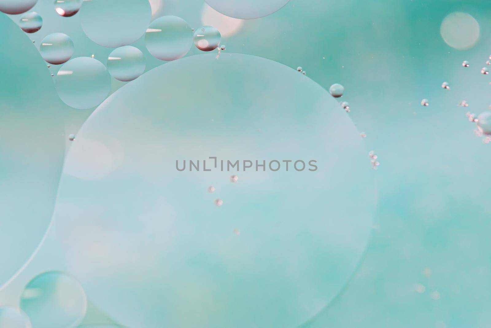 Oil drops in water. Defocused abstract psychedelic pattern image light blue colored. DOF.