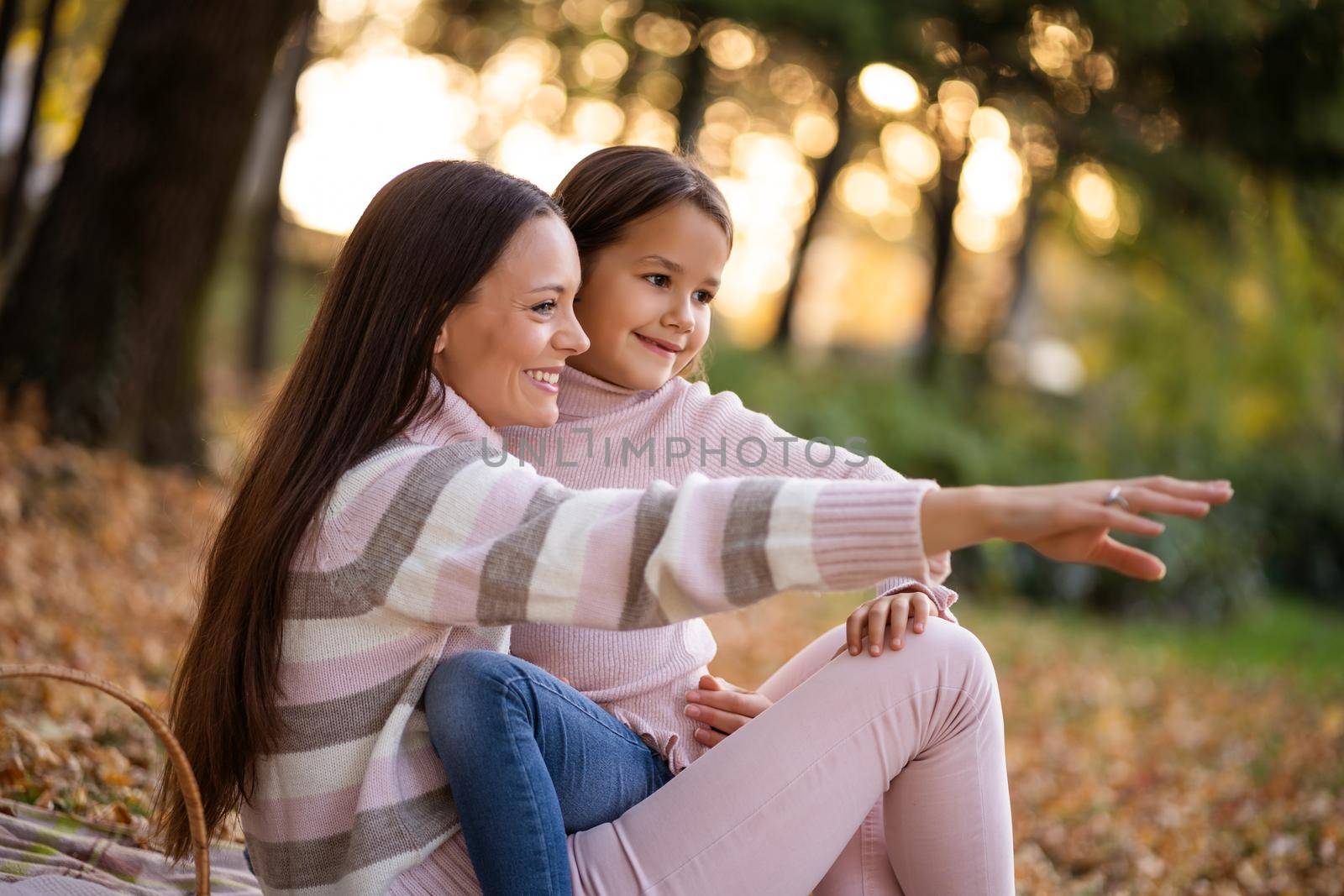 Mother and daughter enjoying autumn in park.