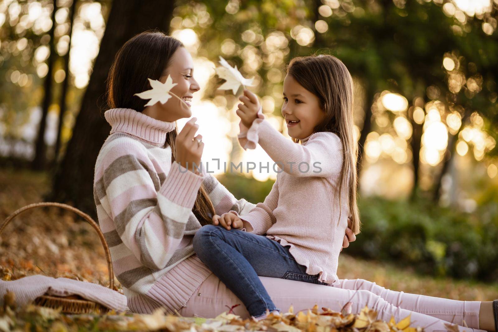 Mother and daughter enjoying autumn in park.