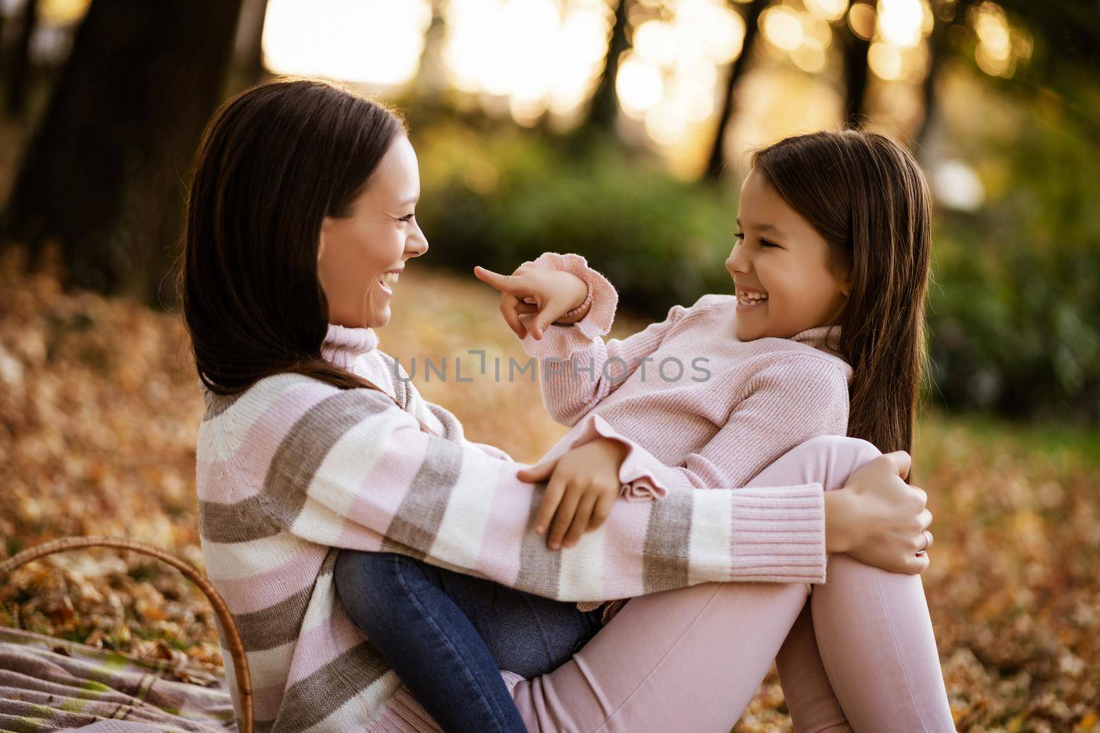 Mother and daughter enjoying autumn in park.