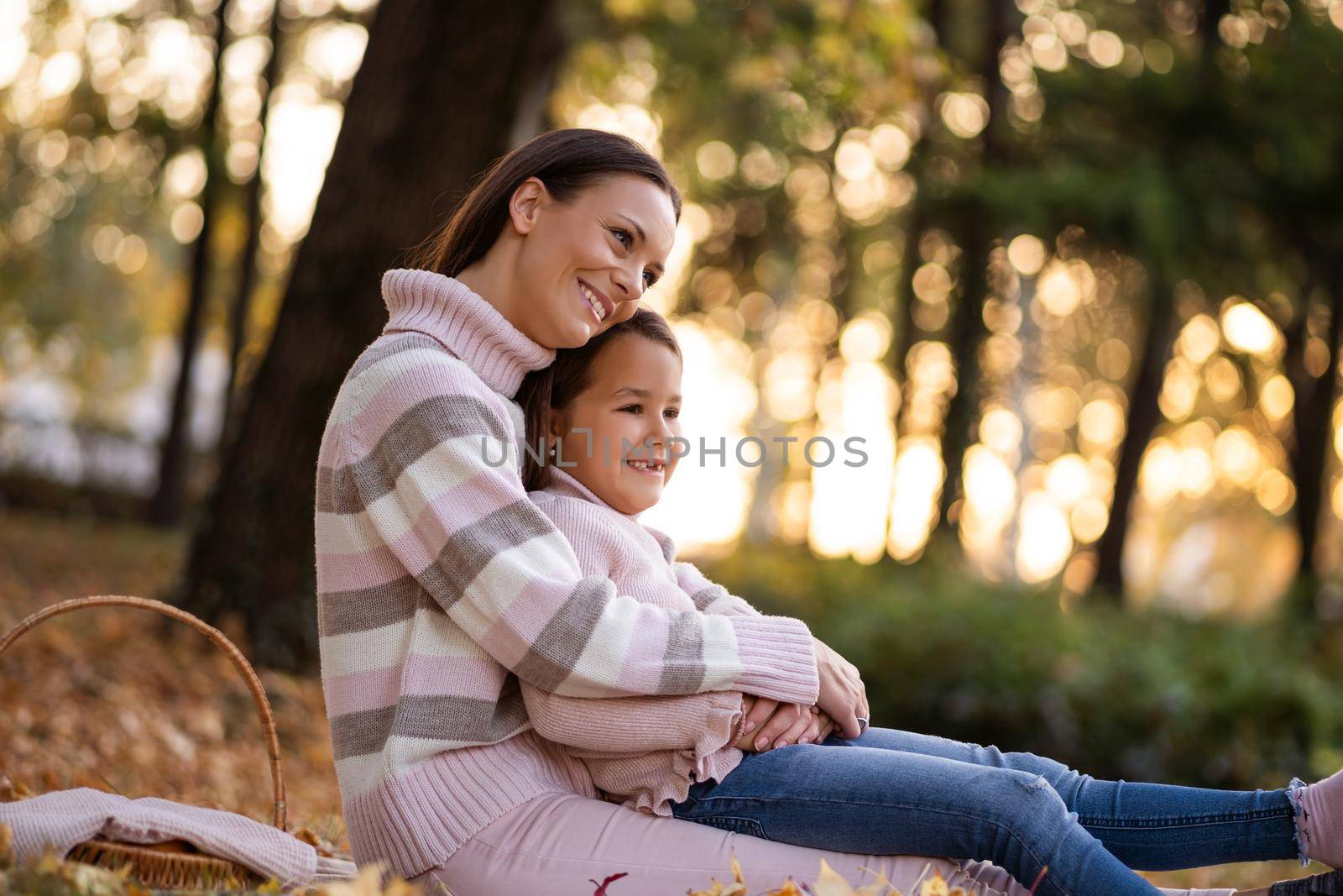 Mother and daughter enjoying autumn in park.