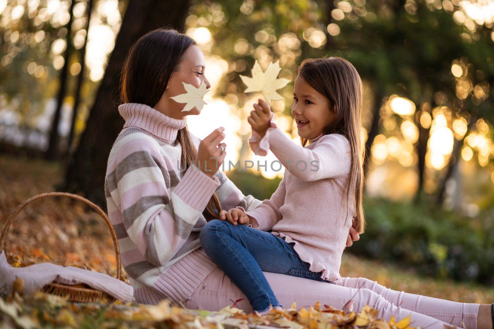 Mother and daughter enjoying autumn in park.