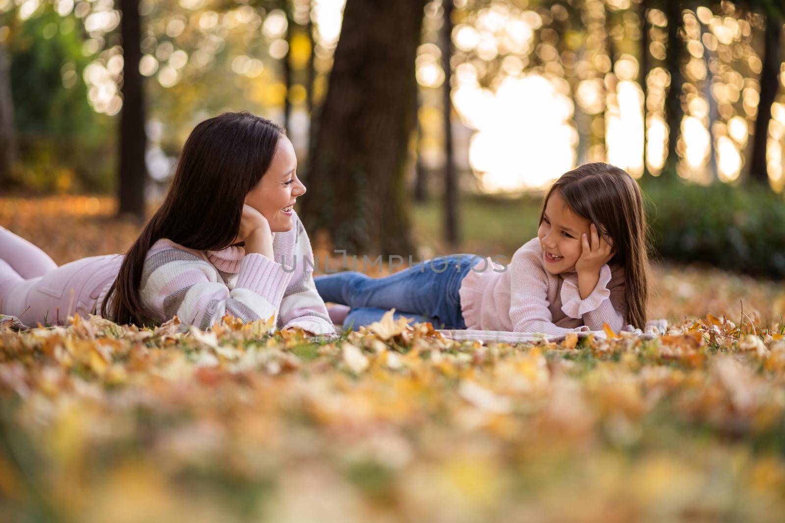 Mother and daughter enjoying autumn in park.