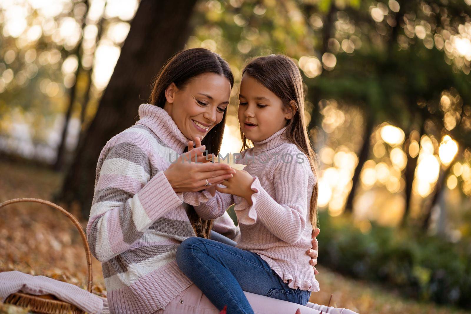 Mother and daughter enjoying autumn in park.