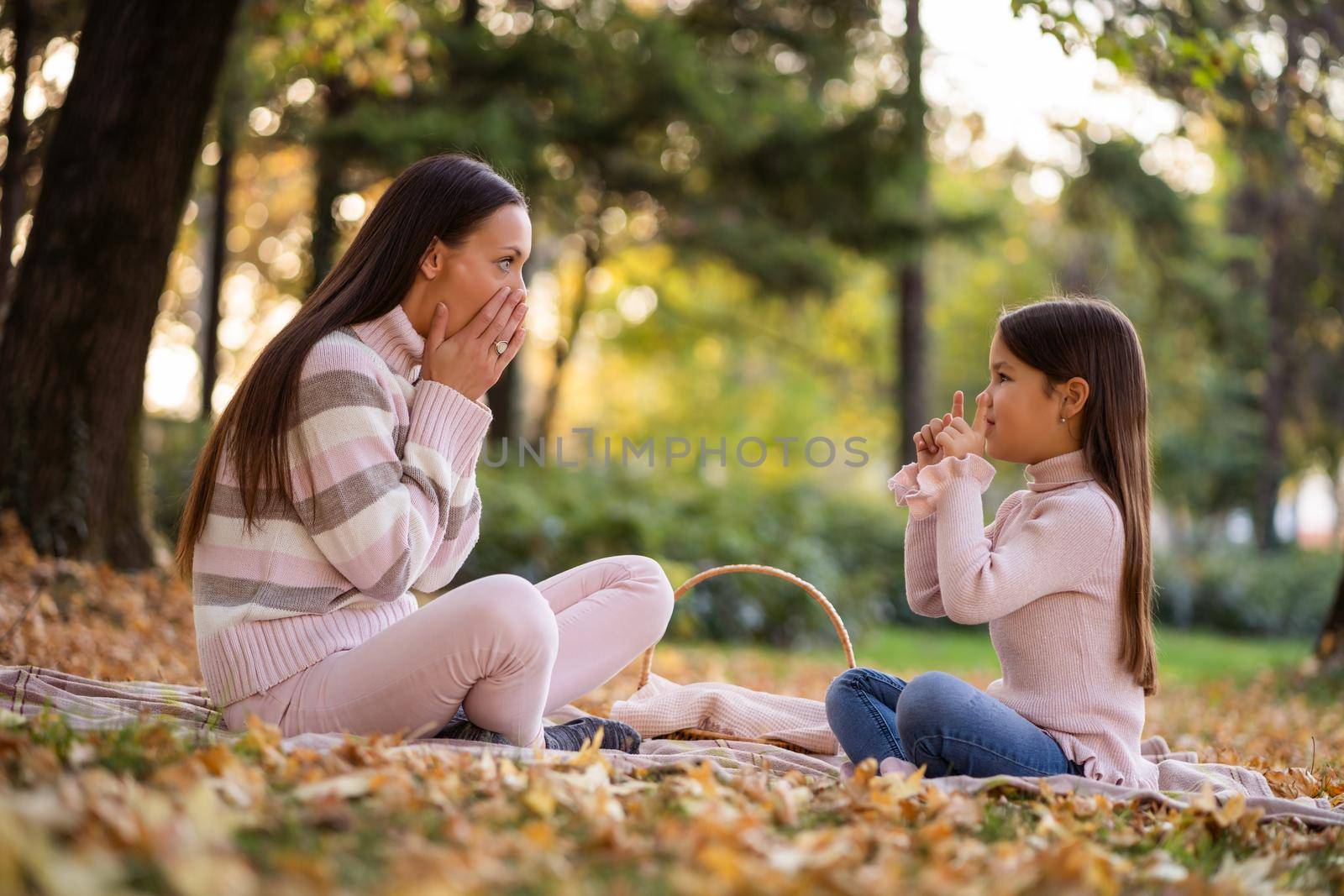 Mother and daughter enjoying autumn in park.