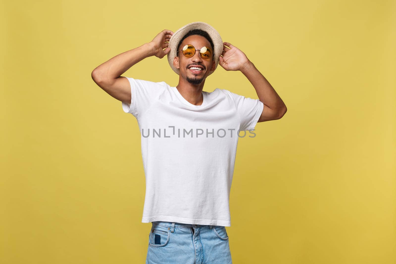 Close up portrait of young afro american shocked tourist , holding his eyewear, wearing tourist outfit, hat, with wide open eyes