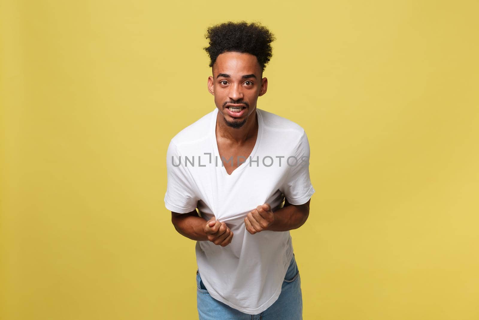 Portrait of angry or annoyed young African American man in white shirt looking at the camera with displeased expression. Negative human expressions, emotions, feelings. Body language