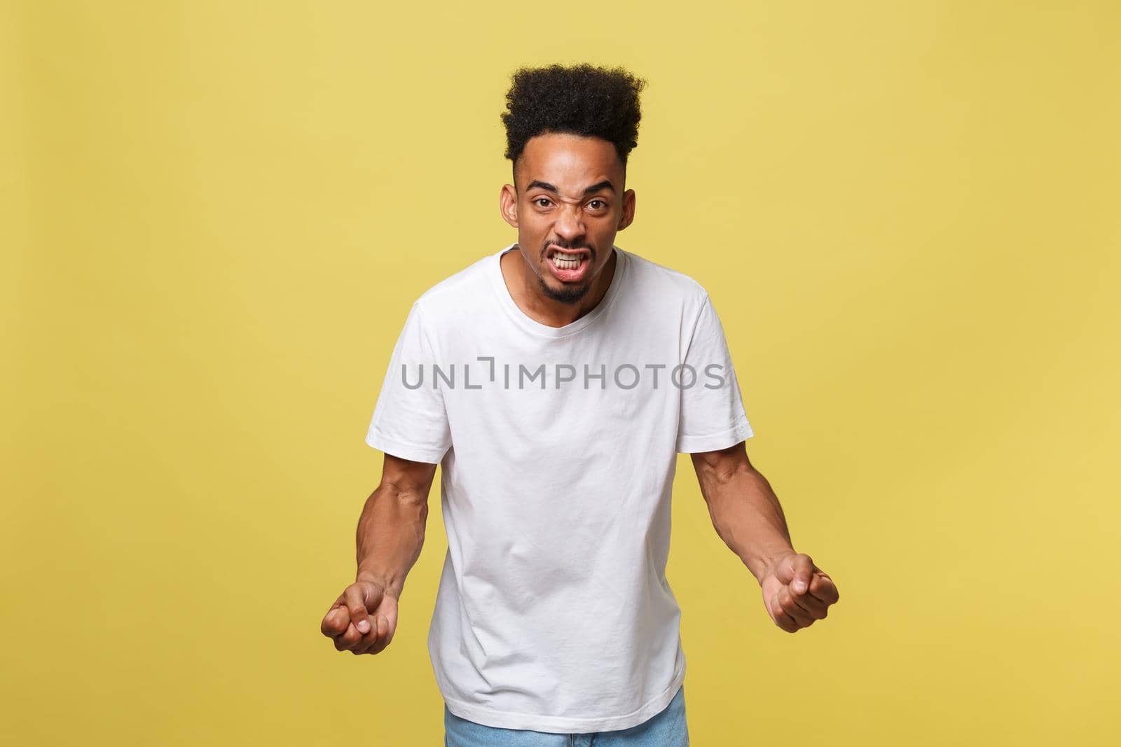 Portrait of angry or annoyed young African American man in white shirt looking at the camera with displeased expression. Negative human expressions, emotions, feelings. Body language