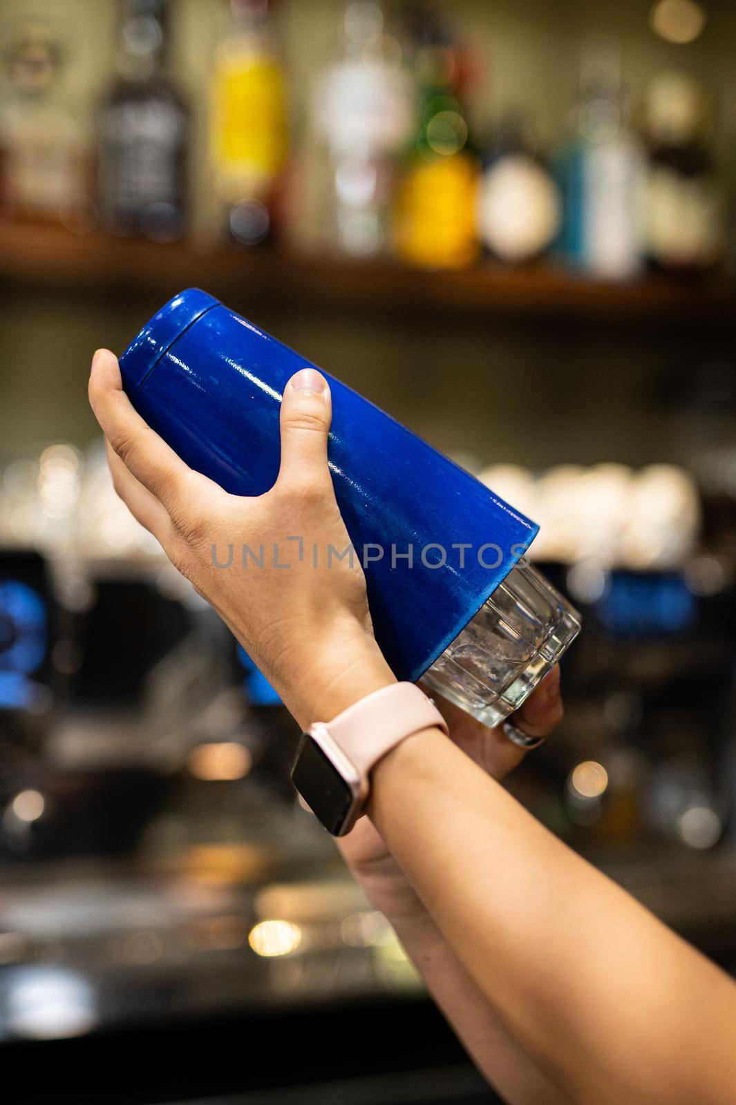 woman hand with shaker preparing coktail by carfedeph