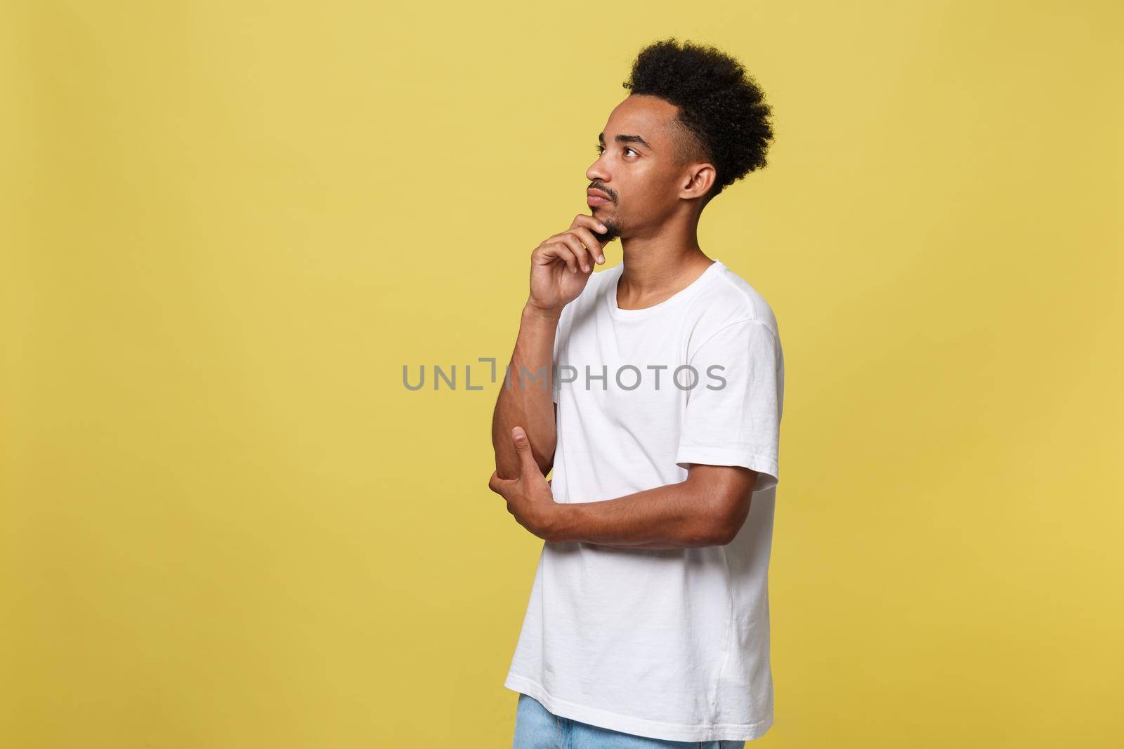 Handsome African-American teenager with casual cloth isolated on yellow background. by Benzoix