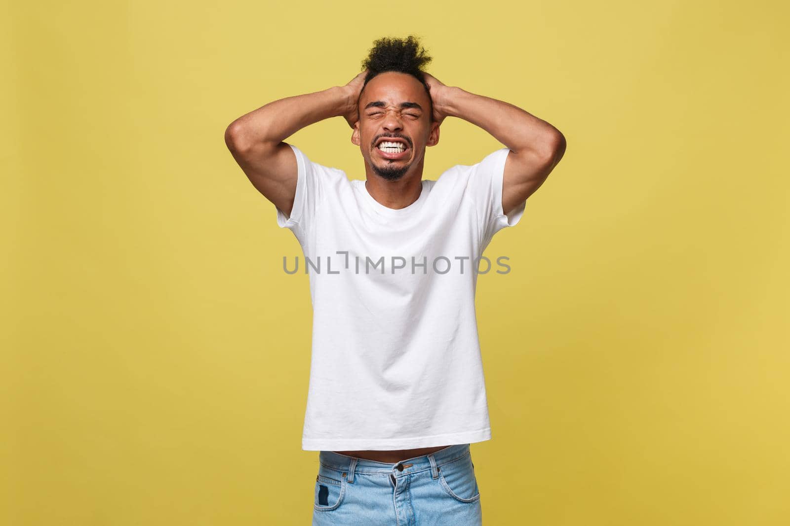 Portrait of angry or annoyed young African American man in white shirt looking at the camera with displeased expression. Negative human expressions, emotions, feelings. Body language