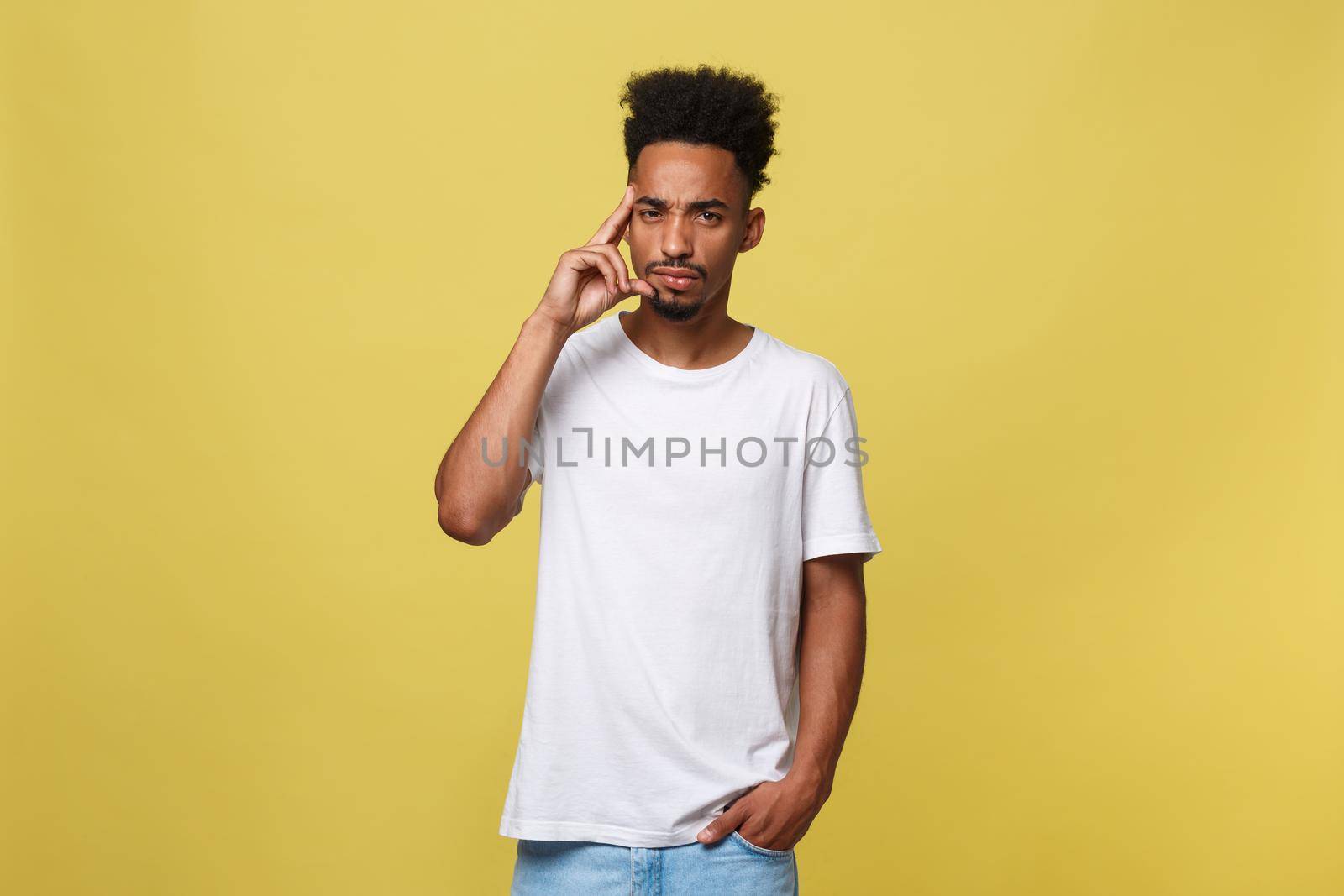 Handsome African-American teenager with casual cloth isolated on yellow background. by Benzoix