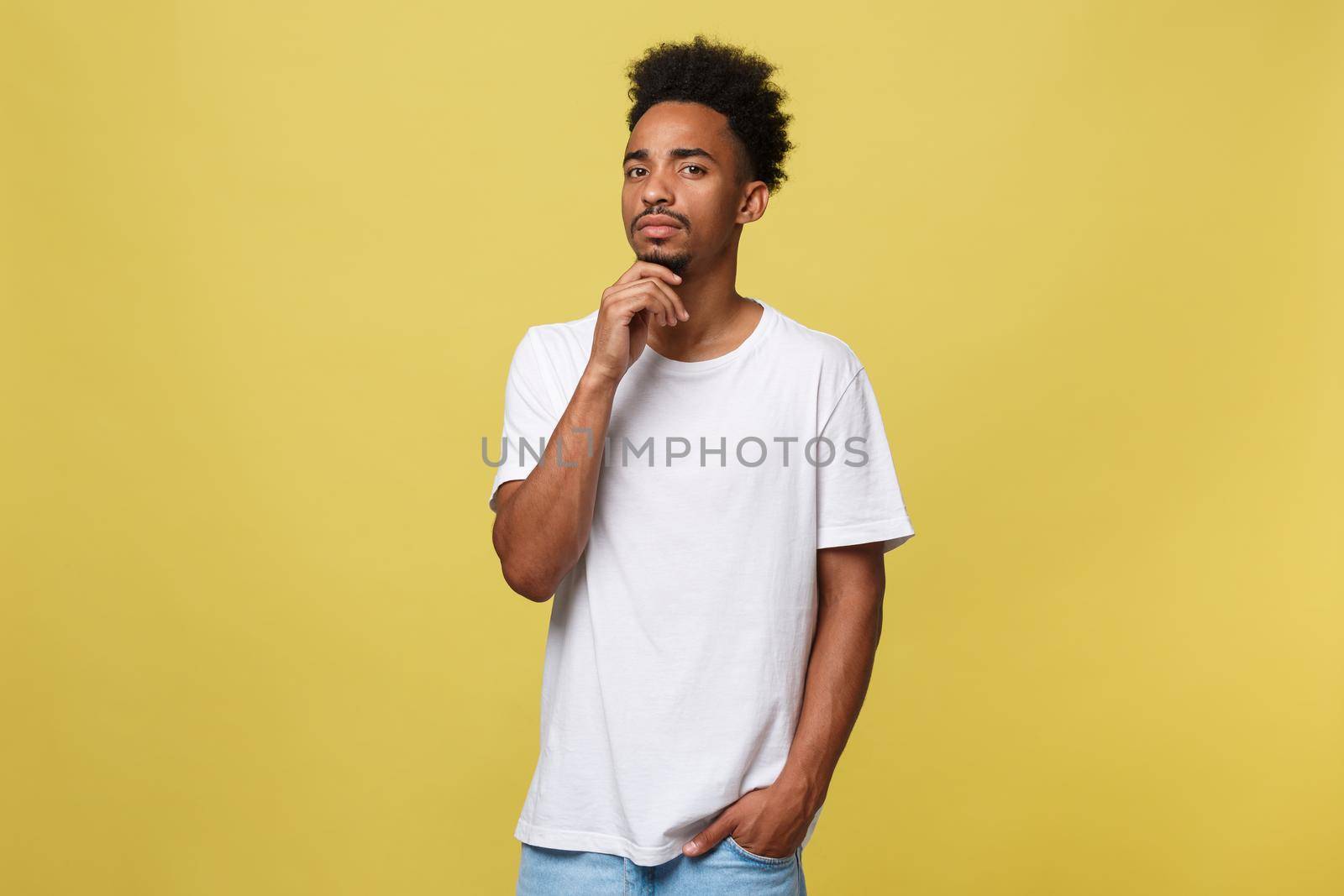 Handsome African-American teenager with casual cloth isolated on yellow background. by Benzoix