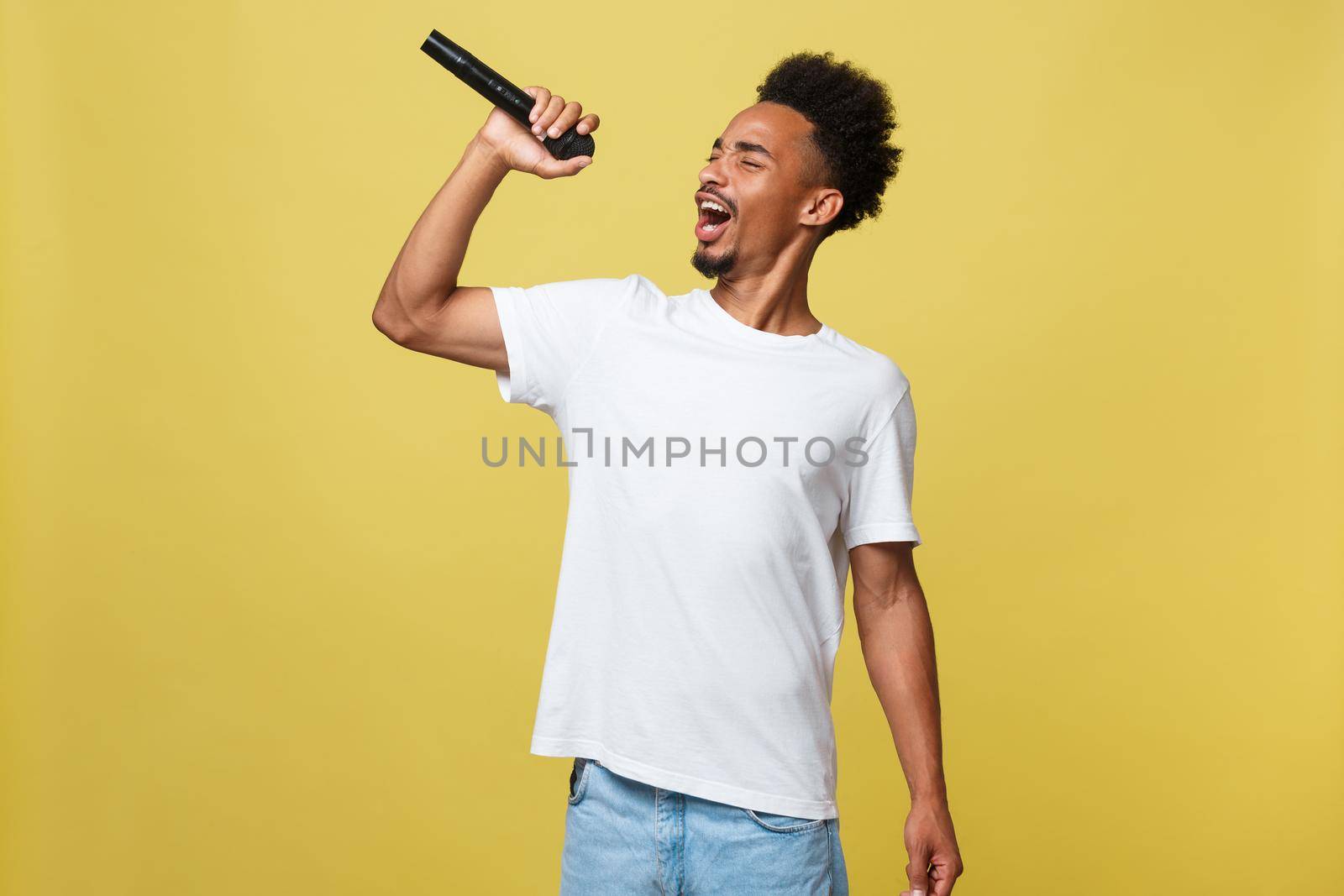 young handsome african american boy singing opera emotional with microphone