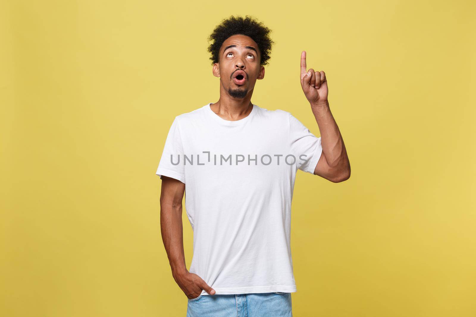 Young handsome african american man over yellow background pointing upwards. by Benzoix